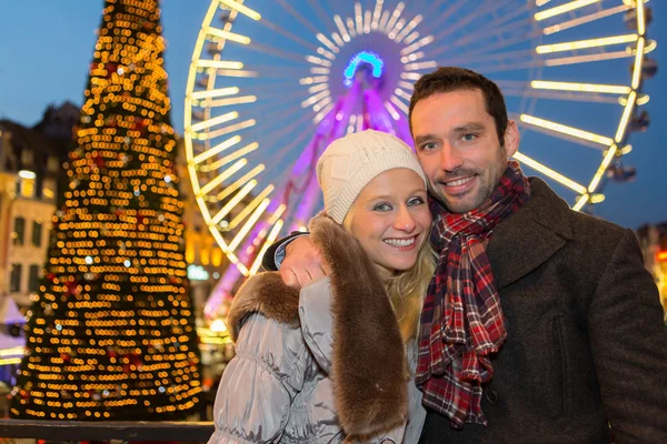 Young attractive couple in a christmas market — Stock Photo, Image