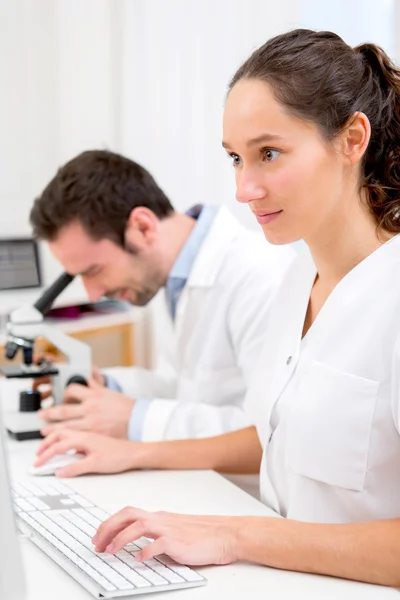 Científica y su asistente en un laboratorio —  Fotos de Stock