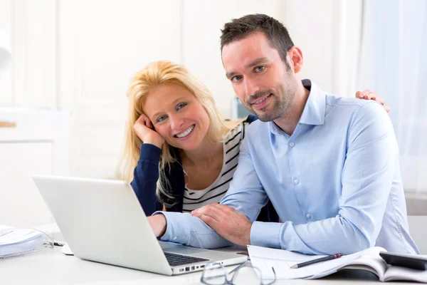 Jovem casal atraente usando laptop em casa — Fotografia de Stock