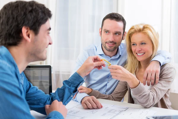 Real estate handing over keys to couple — Stock Photo, Image