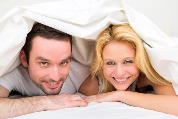 ベッドで若い幸せなカップルの肖像画 — ストック写真