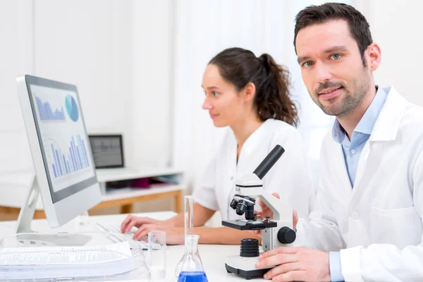 Cientista e sua assistente em um laboratório — Fotografia de Stock