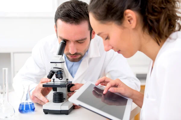 Cientista e sua assistente em um laboratório — Fotografia de Stock