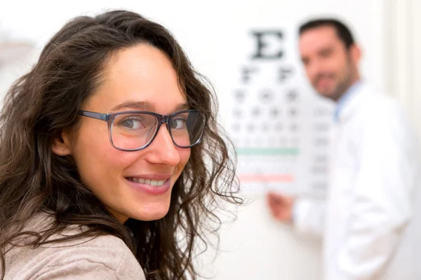 Mujer atractiva joven haciendo prueba de óptica — Foto de Stock