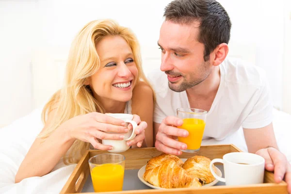 Retrato de um casal tomando café da manhã na cama — Fotografia de Stock