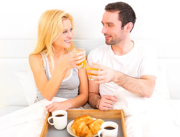 Portrait of a couple having breakfast in bed — Stock Photo, Image