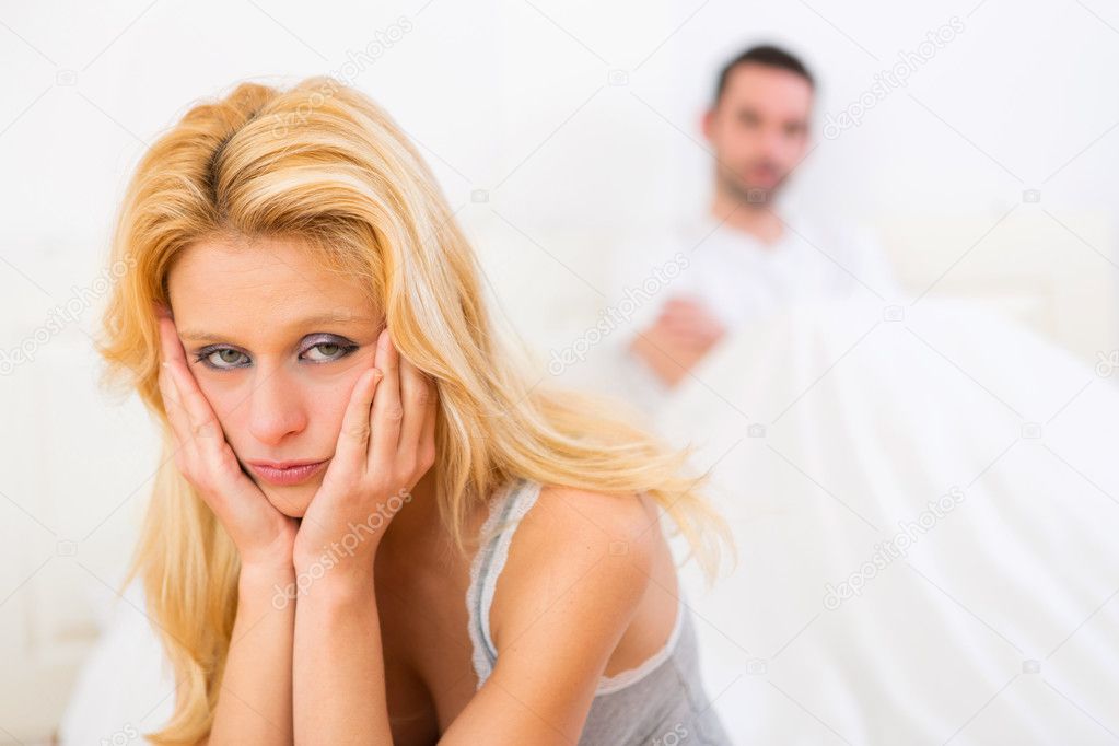 Young attractive couple having an argue in bed