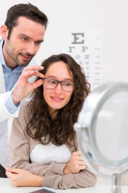 Gözlük seçmek için bir kadın yardım gözlükçü