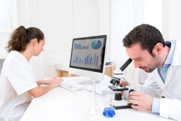 Forskare och hennes assistent i ett laboratorium — Stockfoto