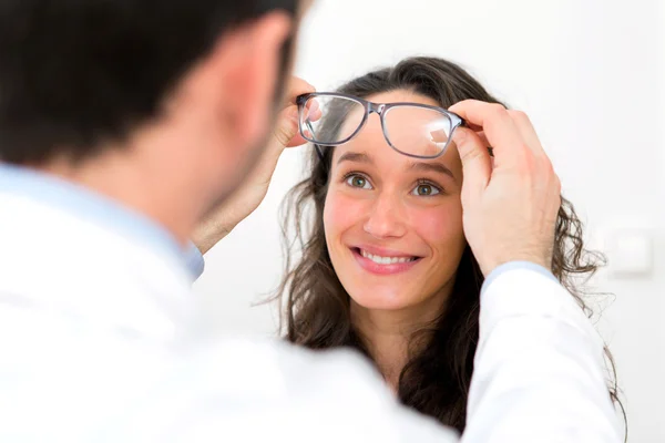 Giovane donna attraente cercando occhiali w ottico — Foto Stock