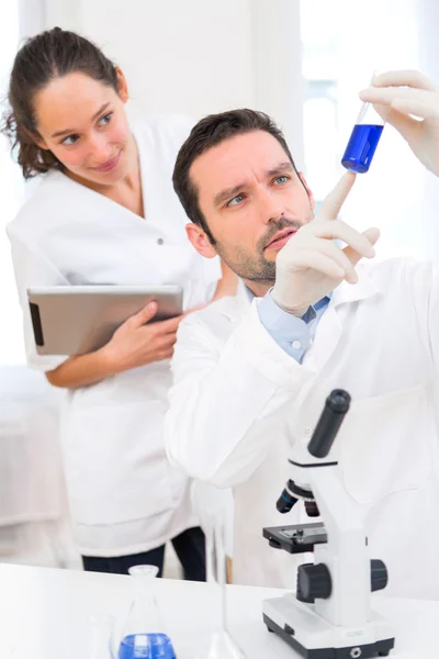 Cientista e seu assistente trabalhando em um laboratório — Fotografia de Stock