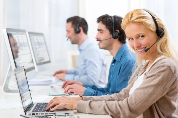 Jonge aantrekkelijke vrouw die werkt in een callcenter — Stockfoto