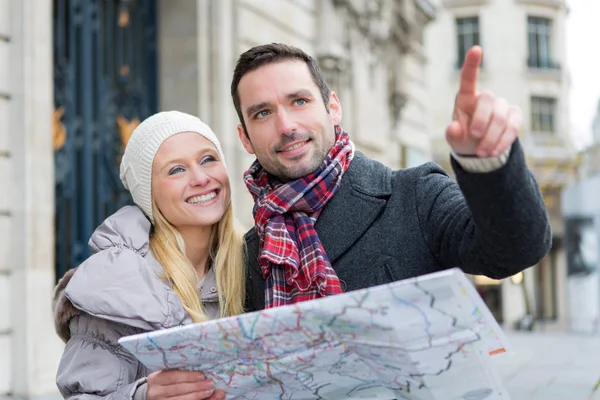 Couple of young attractive tourist watching map — Stock Photo, Image