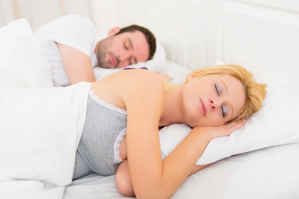 Young attractive couple sleeping in a bed — Stock Photo, Image