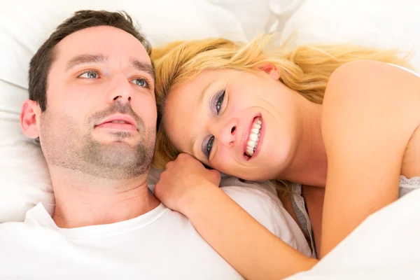 Retrato de una joven pareja feliz en una cama — Foto de Stock