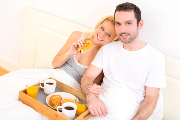 Retrato de um casal tomando café da manhã na cama — Fotografia de Stock