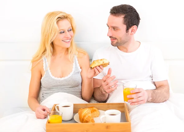 Retrato de um casal tomando café da manhã na cama — Fotografia de Stock