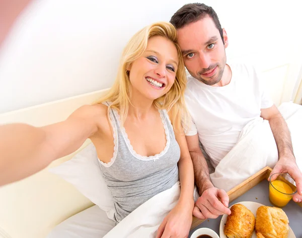 Jovem casal atraente tomando selfie durante o café da manhã — Fotografia de Stock