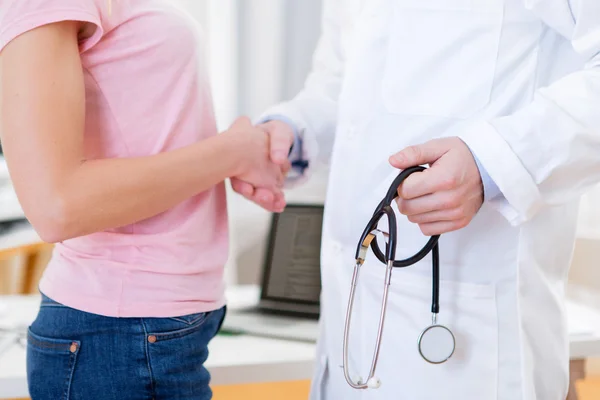 Young attractive doctor shaking hand of his patient — Stock Photo, Image