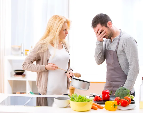 Jonge aantrekkelijke paar met een debatteren tijdens het koken — Stockfoto