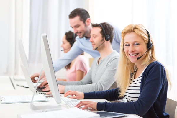 Giovane donna attraente che lavora in un call center — Foto Stock