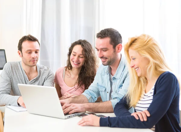 Groep 4 aantrekkelijke jongeren werken op een laptop — Stockfoto