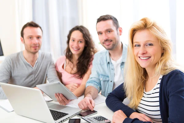 Gruppo di 4 giovani attraenti che lavorano su un computer portatile — Foto Stock