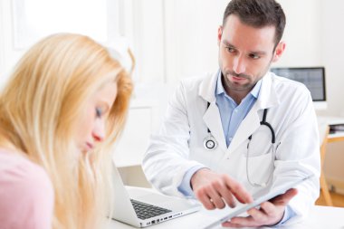 Genç Doktor hastaya tablet üzerinde gösterilen sonuçlar