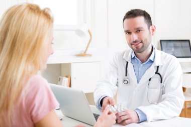 Bir hasta için hapları vermeye genç çekici doktor