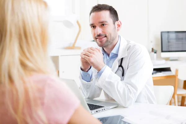 Young attractive doctor listening his patient — Stock Photo, Image