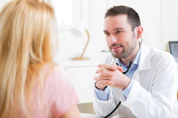 Young attractive doctor listening his patient — Stock Photo, Image