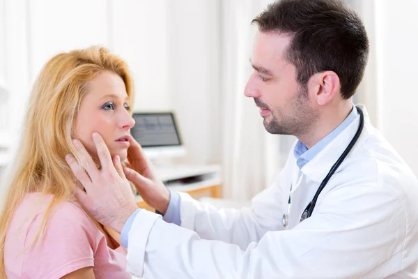 Young attractive doctor analysing blonde patient face — Stock Photo, Image