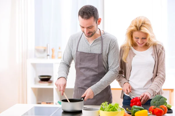 Joven pareja atractiva cocinando en una cocina —  Fotos de Stock