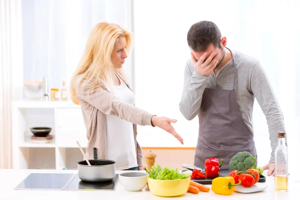 Jovem casal atraente tendo uma discussão enquanto cozinha — Fotografia de Stock