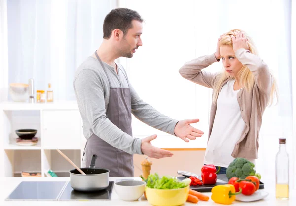 Jonge aantrekkelijke paar met een debatteren tijdens het koken — Stockfoto