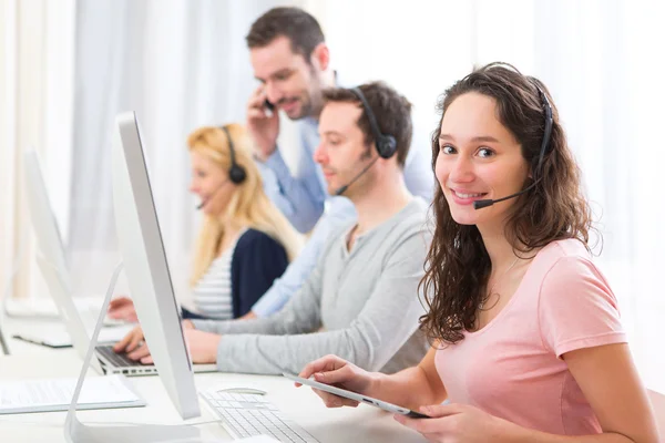 Ung attraktiv kvinna som arbetar i ett callcenter — Stockfoto