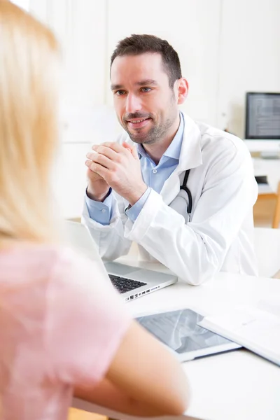 Giovane medico attraente ascoltando il suo paziente — Foto Stock