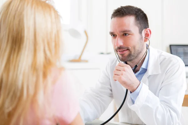 Young attractive man listenning in his stethoscope — Stock Photo, Image