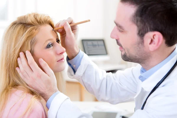 Jonge aantrekkelijke dokter schrijven op patiënt gezicht — Stockfoto