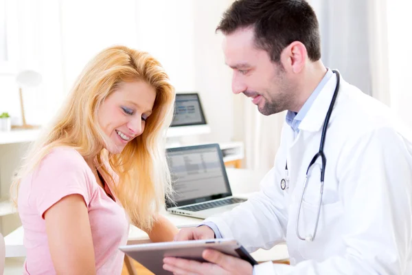 Young doctor showing results on tablet to patient — Stock Photo, Image