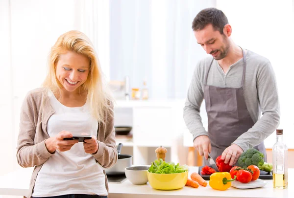 Young attractive woman writing text in kitchen — Stock Photo, Image