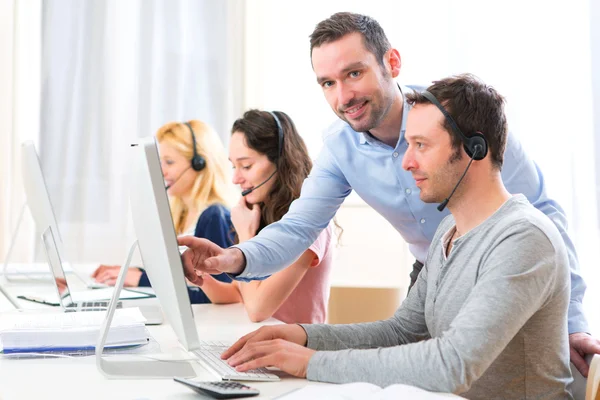 Manager training een aantrekkelijke jongeren op computer — Stockfoto