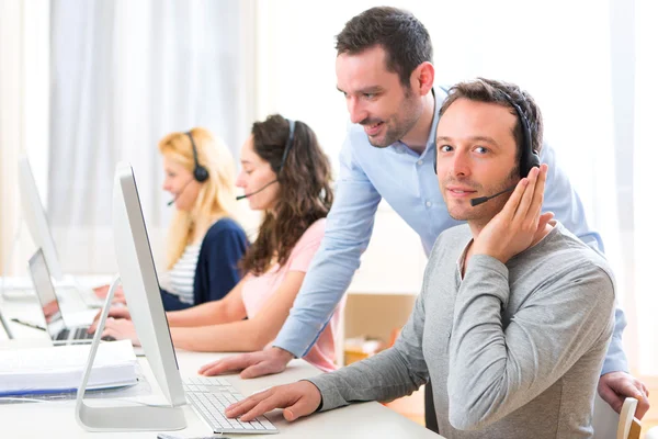 Manager training een aantrekkelijke jongeren op computer — Stockfoto