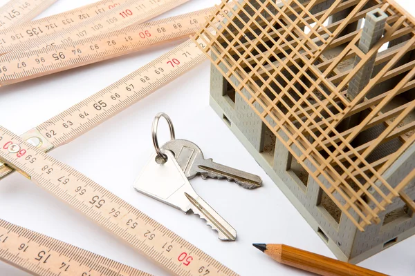 Casa em miniatura em construção em uma mesa de arquiteto — Fotografia de Stock