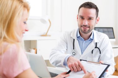 Hasta genç çekici doktor belge imzalama