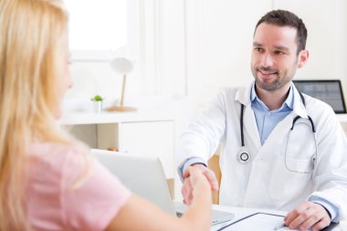 Genç çekici Doktor hastasına el sallayarak