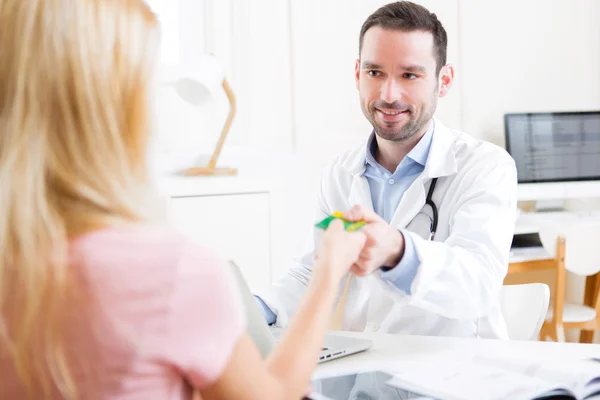 Jonge aantrekkelijke dokter nemen ziekteverzekeringskaart — Stockfoto