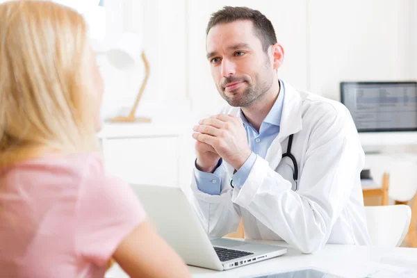 Молодой привлекательный врач слушает своего пациента — стоковое фото