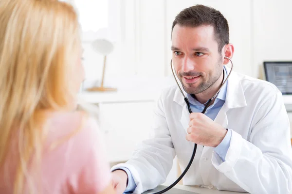 Jeune homme attrayant à l'écoute dans son stéthoscope — Photo