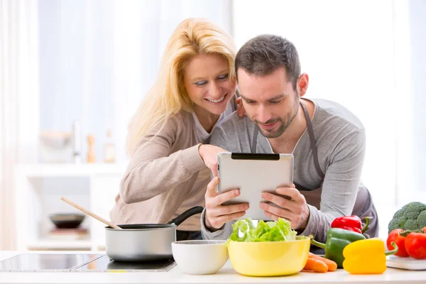 Jovem atraente casal leitura receita em um tablet — Fotografia de Stock